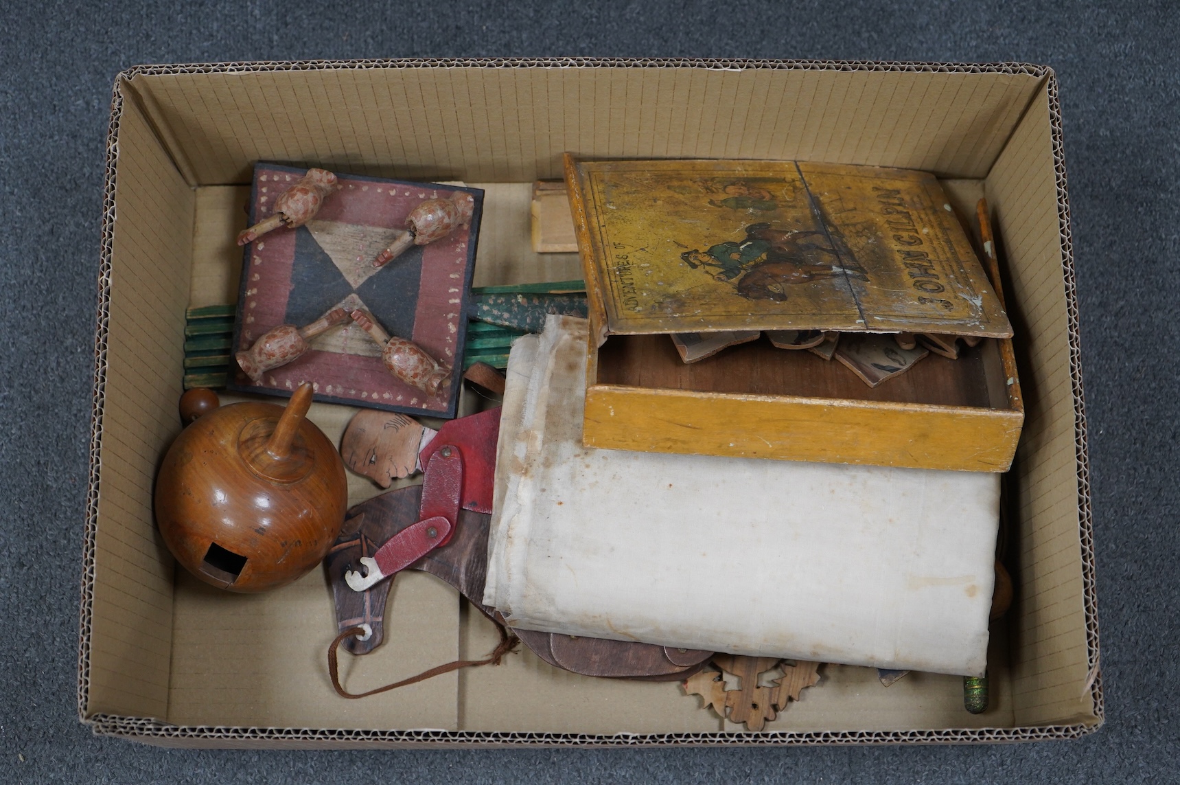 A collection of 19th century toys including; an early Jaques Ping Pong or Gossima set in an illustrated wooden case, a Crandall’s John Gilpin wooden horse with folded linen backed poster, ‘The Adventures of John Gilpin’